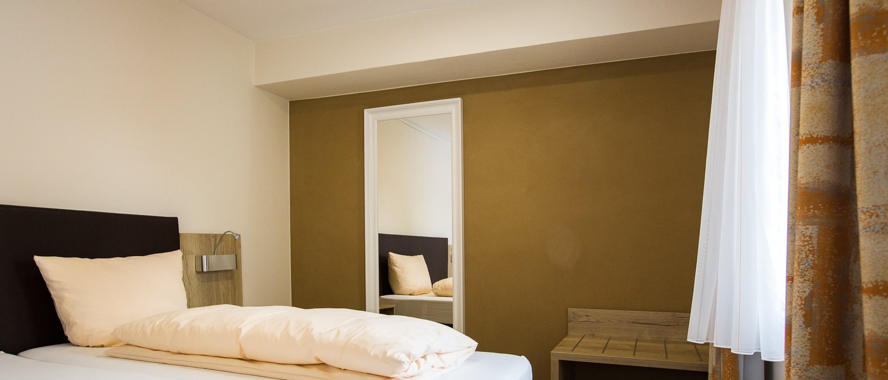 Schlafzimmer mit olivfarben gestrichenen Lehmwänden