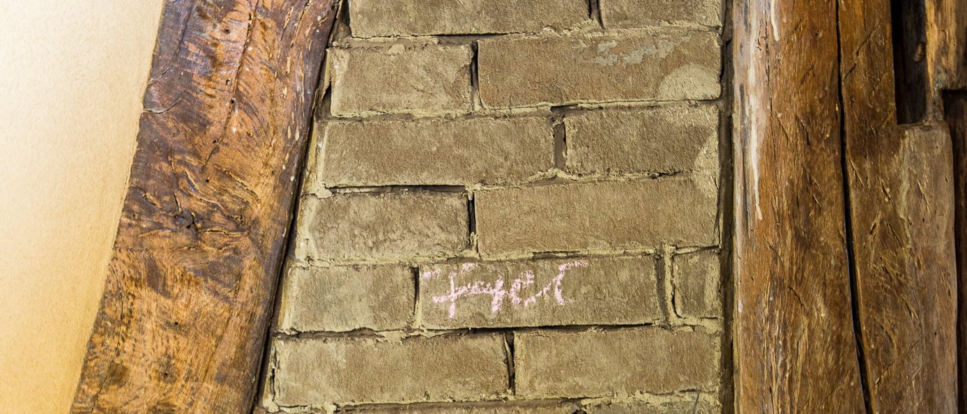 Mit Lehmsteinen ausgemauertes Gefach zwischen historischen Eichenbalken